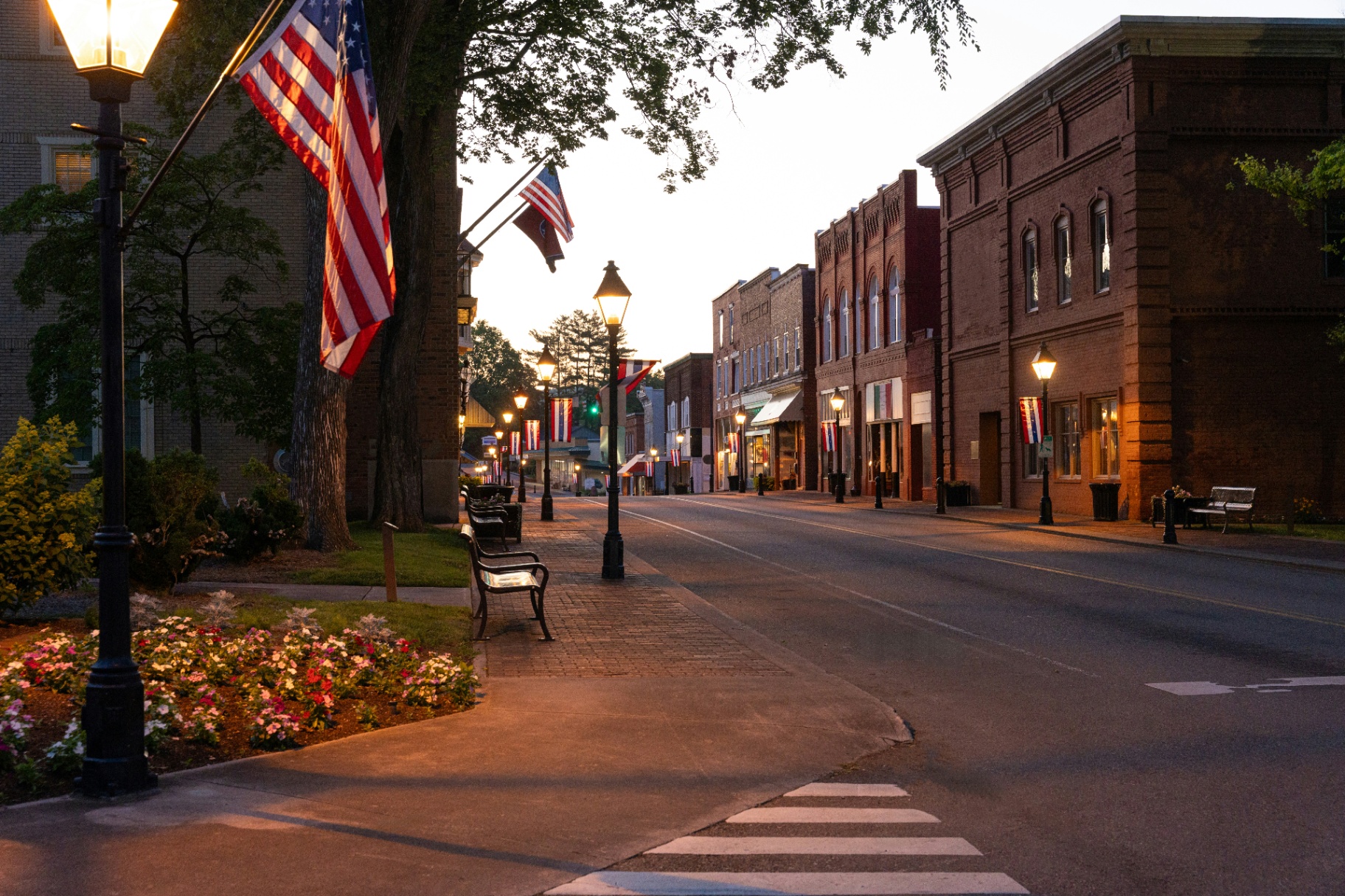 Charming Main Street in Watertown Wisconsin at dusk with American flags and historic brick buildings